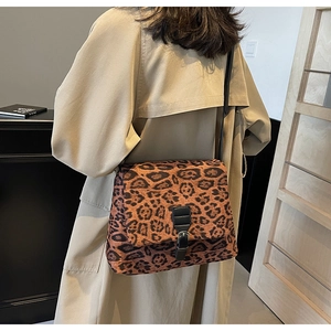 Dettaglio della borsa a tracolla leopardata con fibbia in pelle nera e consistenza morbida
