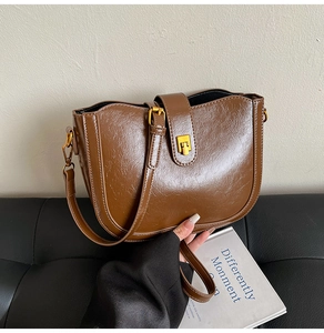 Detail der braunen Vintage-Beuteltasche aus PU-Leder mit goldenem Metallverschluss