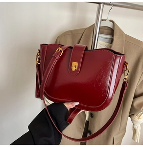 Detail der vintage weinroten Leder-Beuteltasche mit goldener Metallschnalle