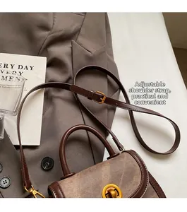 Detail of color-block saddle bag featuring brown leather, canvas panels, and gold twist lock