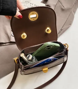 Deep brown crossbody saddle bag featuring two inner compartments for essentials