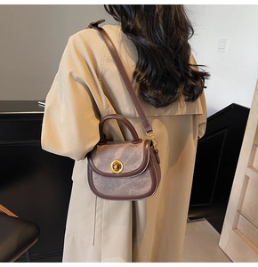 Detail of vintage patchwork leather square bag with gold metal lock and top handle