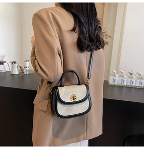 Detail of a vintage color-block saddle bag featuring a gold clasp on a model's shoulder