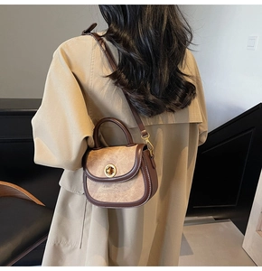 Close-up of retro brown saddle bag with gold ring buckle and shoulder strap