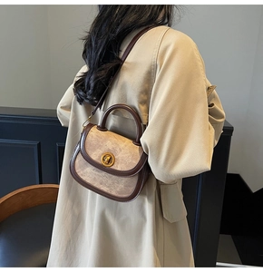 Detail of vintage saddle bag with beige textured leather and dark brown trim