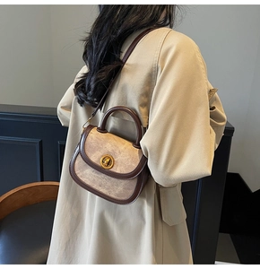 Close-up of a vintage brown marble-textured crossbody bag on a model in a trench coat