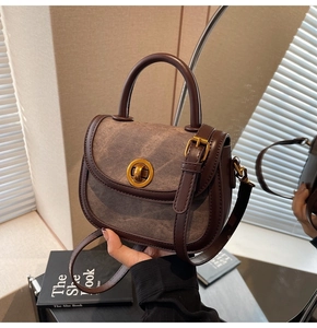 Detail view of vintage coffee saddle bag with metallic turn-lock and adjustable strap