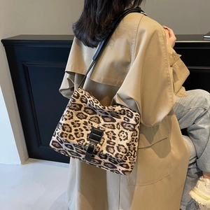 Borsa a tracolla leopardata alla moda con cinturino in pelle nera su un trench coat