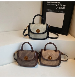 Three-color saddle bags with round gold twist locks on minimalist white steps display