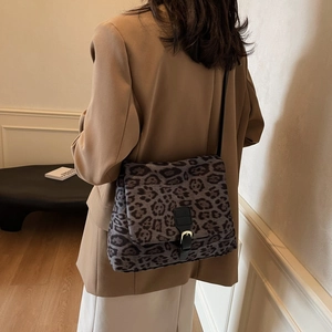 Borsa a spalla leopardata alla moda con fibbia dorata da donna in un ambiente moderno