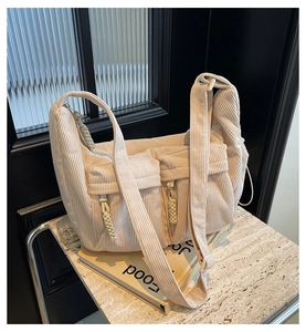 Detail der cremefarbenen Cord-Einkaufstasche mit Vordertaschen und geflochtenen Zippern