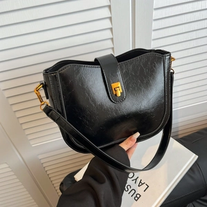 Vintage Eimertasche aus schwarzem Wachsleder mit Goldschnalle und Faltenstruktur