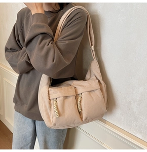 Detail der beigen Cord-Tragetasche mit großen Vordertaschen und geflochtenen Zügen