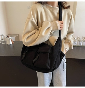 Nahaufnahme der schwarzen Cord-Umhängetasche mit Multi-Taschen und Reißverschlussdetails