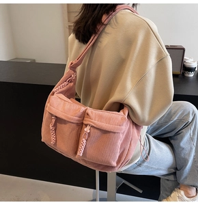 Detailansicht der rosa Cord-Tragetasche mit Vordertaschen und gewebten Reißverschlüssen