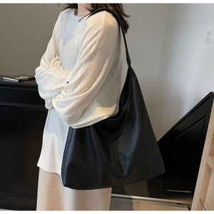 Close-up of minimalist black oversized tote bag with premium pebble texture leather