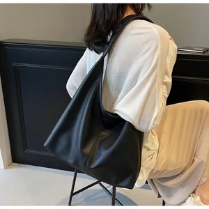 Detail of a black pebbled leather hobo bag showing texture and large capacity
