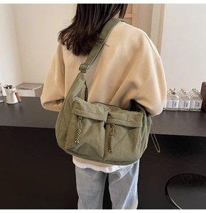 Detail der grünen Cord-Tasche mit doppelten Fronttaschen und gewebtem Kordelzug-Design
