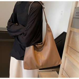 Close-up of brown pebbled leather hobo bag showing large capacity and soft texture
