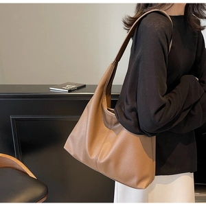 Macro shot of brown leather texture and stitching on this large capacity tote bag
