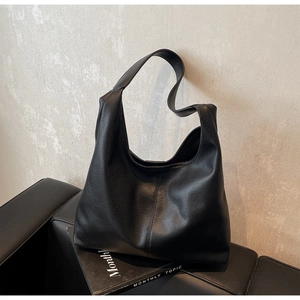 Detail of black pebbled leather tote bag with large capacity and vertical seam design