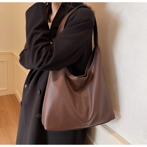 Close-up of deep brown lychee grain leather texture on large capacity shoulder bag