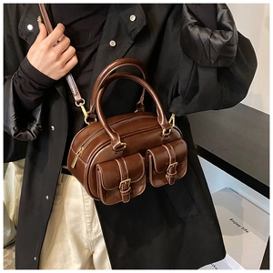 Detail of dark brown vintage bowling bag showing dual front pockets and bronze hardware