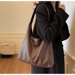 Detail of dark brown lychee leather hobo bag showing texture and structural vertical stitching