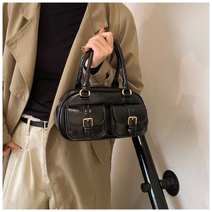 Detail of black retro bowling bag featuring shiny PU leather and gold buckle pockets