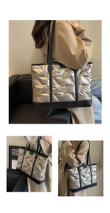 Close-up of champagne gold quilted tote bag with black leather straps and base details