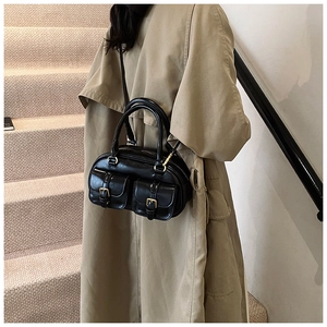Retro black bowling handbag with decorative front pockets and gold hardware styling