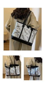 Detail view of silver quilted tote bag featuring black leather handles and trim accents
