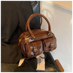 Macro detail of brown vintage faux leather handbag with metal buckles and pockets