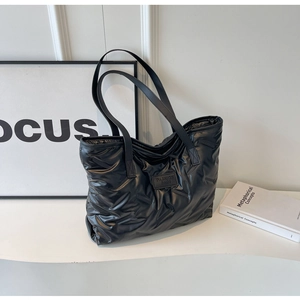 Vue détaillée du sac cabas matelassé noir avec étiquette mode et texture en nylon brillant