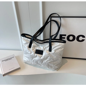 Détails du sac cabas matelassé métallisé avec bordure noire et logo de mode élégant