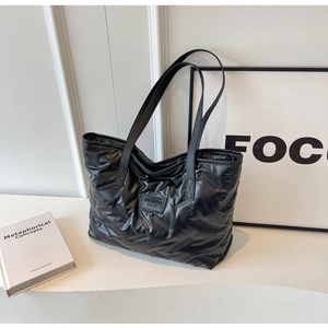 Vue détaillée du sac cabas matelassé noir brillant avec écusson en cuir de mode