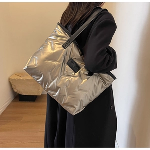 Détail du sac fourre-tout matelassé argenté avec étiquette FASHION BAGS et anses