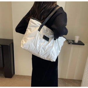 Détail du grand sac cabas matelassé blanc avec bandoulière noire et patch logo
