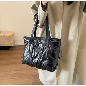 Détail du sac cabas matelassé noir avec motif à losanges et écusson en cuir Fashion Bags