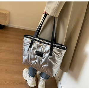 Vue détaillée du sac cabas matelassé argenté avec finition métallique et logo