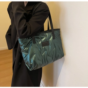 Détail du sac cabas matelassé vert métallisé avec surpiqûres en V et logo tendance
