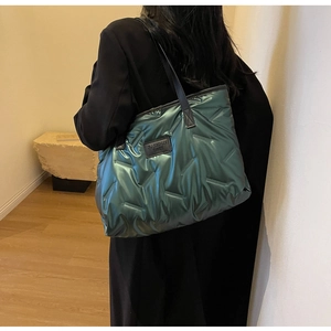 Détail du sac fourre-tout vert métallisé avec surpiqûres en V et anses en cuir