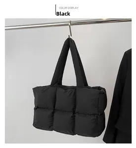 Detail of black quilted down tote bag hanging on a display rack with sleek nylon finish