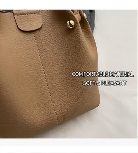 Detailed close-up of brown lychee grain leather texture with white stitching and gold hardware