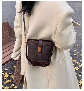 Detail of vintage leopard print bucket bag with gold twist lock on wool coat background
