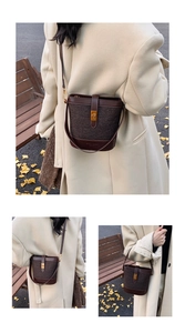 Detail view of a vintage dark brown tweed bucket bag with adjustable shoulder strap