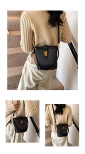 Close-up of a black textured bucket bag with gold hardware and embossed bottom logo