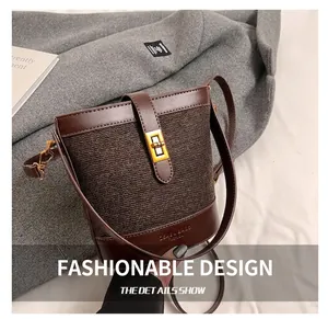 Detailed macro view of woven texture and gold rectangular clasp on a brown bucket bag