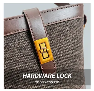 Macro shot of vintage golden hardware clasp on brown tweed and leather bucket bag