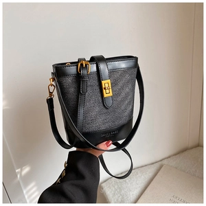 Detail of contrast bucket bag with woven texture and golden turn-lock closure